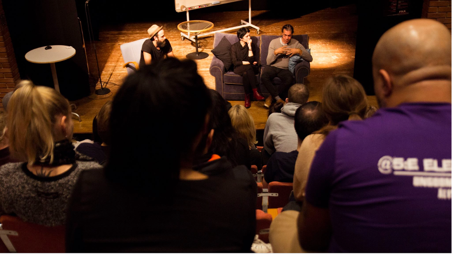 En vy från en läktare där publiken ser ner på en scenföreställning.